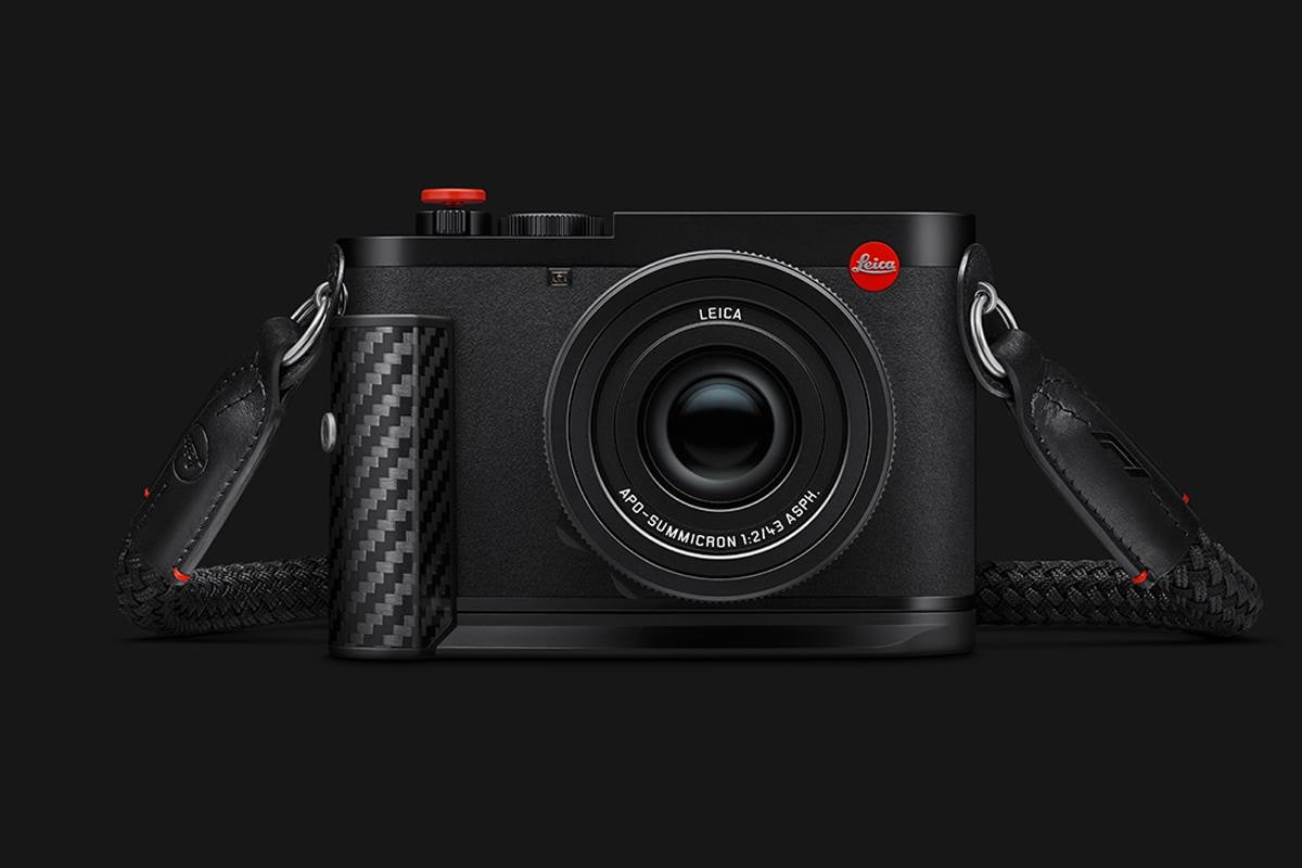 Leica Q3 43 Formula 1® Edition vu de face, avec sa poignée en fibre de carbone et sa courroie en corde